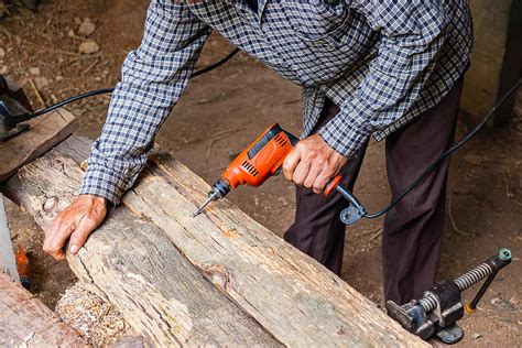 Man using power drill on plank of wood in a woodworking shop 2087207 ...