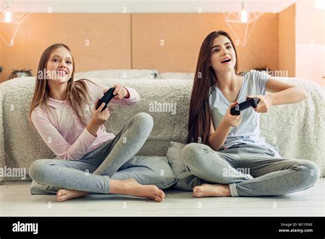 Two teenage sisters playing video game in bedroom Stock Photo - Alamy