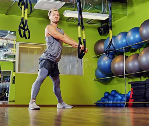 Blond Athletic Male Doing Trx Straps Exercises in a Gym Club. Stock ...