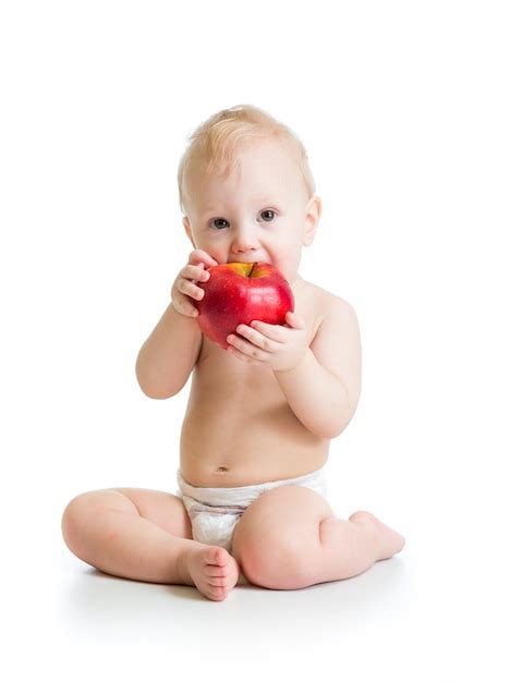 Premium Photo | Baby boy eating red apple, isolated on white