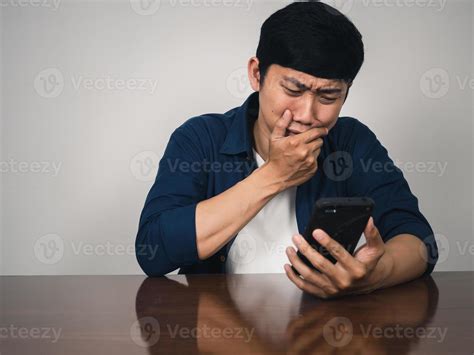 Sadness asian man looking at mobile phone in hand and crying with bad