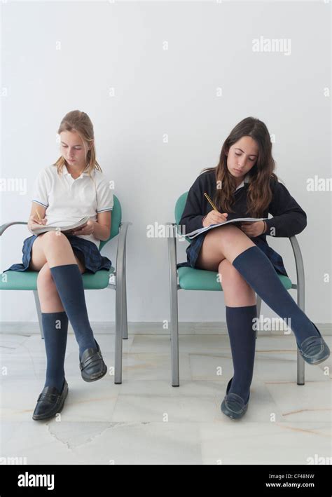 Two Girls Wearing Uniforms Sit On Chairs Doing School Work; Benalmadena Costa Malaga Andalusia ...