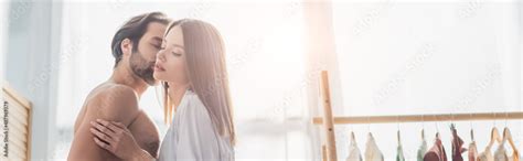 shirtless man kissing young woman  silk robe banner stock photo