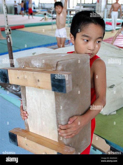 A young chinese athlet enduring a tough training in a Gymnastics school ...