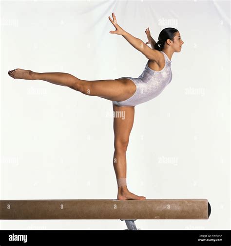 Young female gymnast on balance beam performing, side view Stock Photo - Alamy