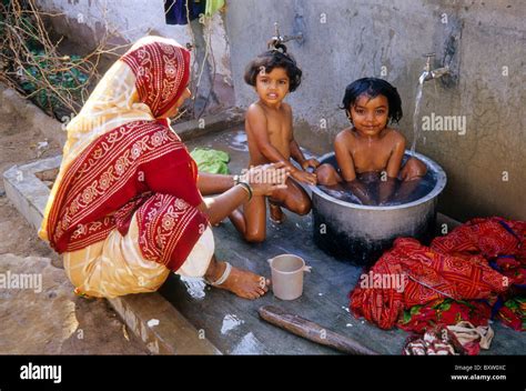 Mother bathing daughters, Bhujodi, Gujarat, India Stock Photo - Alamy