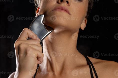 woman uses metal tool for massage and soft tissue mobilization. self