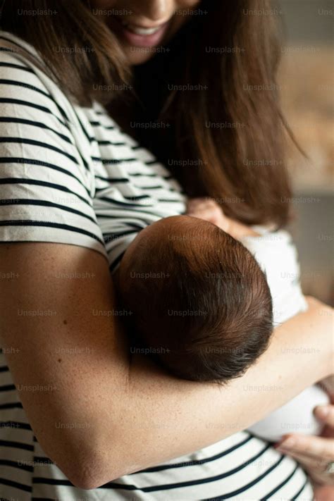 Foto Una mujer sosteniendo a un bebé en sus brazos – Recién nacido