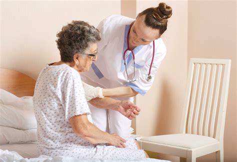Geriatrician helps a senior woman to stand up 26304327 Stock Photo at