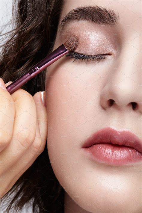 Make-up artist apply beauty makeup on the eyelids of a beautiful ...