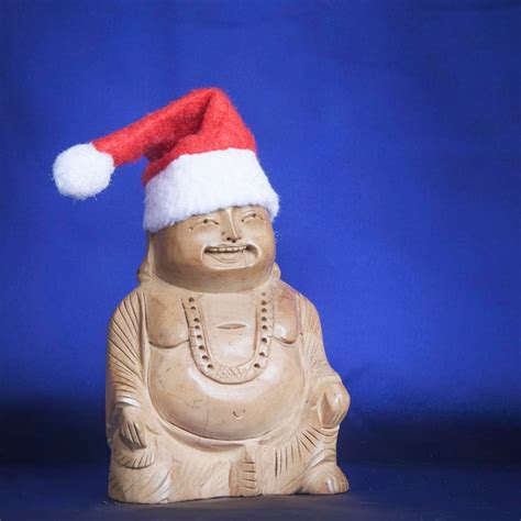 Premium Photo | Wooden figure of happy buddha in a toy christmas hat