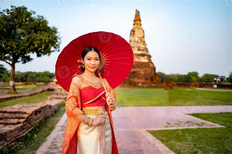 Beautiful Thai girl in traditional dress costume red umbrella as Thai