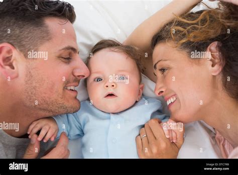 Cute baby with parents in bed Stock Photo - Alamy