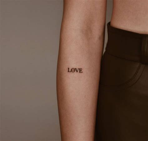 "Love" lettering tattoo on the forearm.