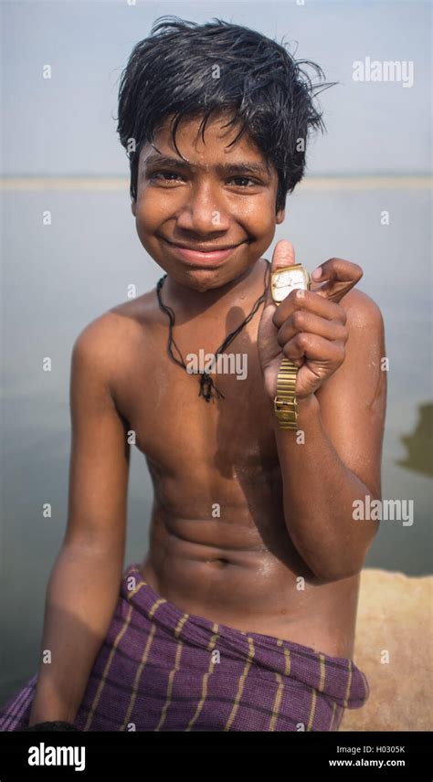 VARANASI, INDIA - 25 FEBRUARY 2015: Indian boy sits shirtless on rock ...