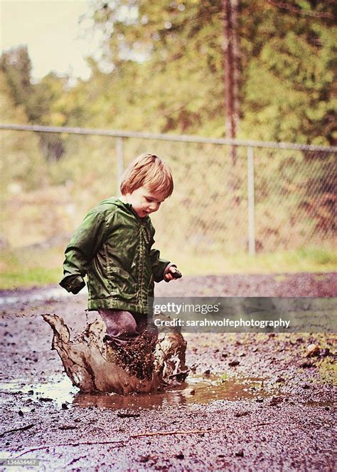 Boy Splashing In Mud Puddle High-Res Stock Photo - Getty Images