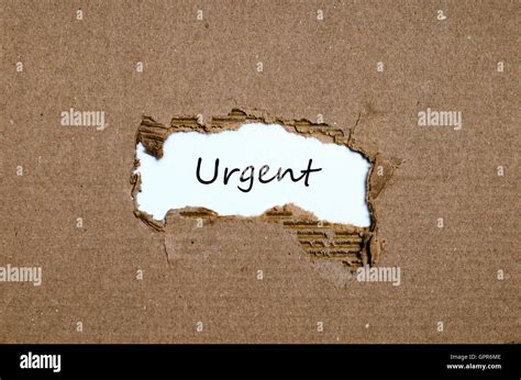 The word urgent appearing behind torn paper Stock Photo - Alamy