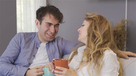 Mature mother and her loving son are chatting. Mother and son sitting