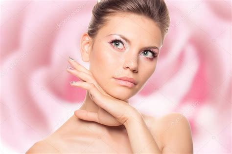Hermosa cara de mujer joven con piel limpia y fresca aislada en rosa