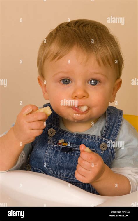 toddler boy ten months old eating fruit Stock Photo - Alamy