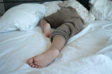 a child sleeping on bed barefoot 26713795 Stock Photo at Vecteezy