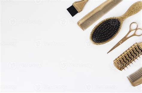 Golden hairdresser tools on a white background, scissors, comb, clip