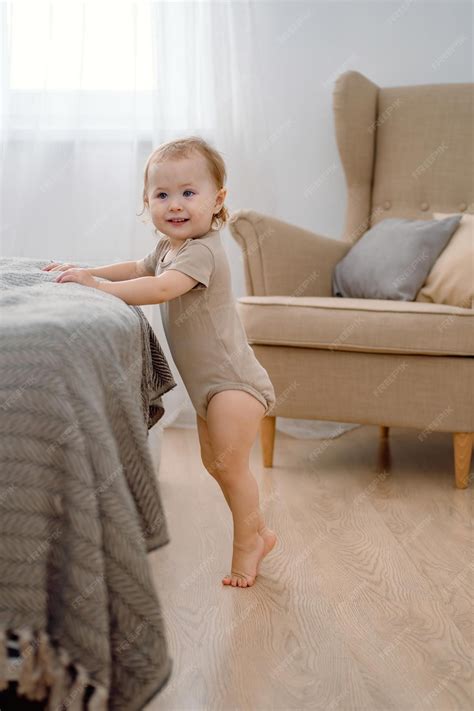 A baby learning to stand up by support a toddler standing on his tip