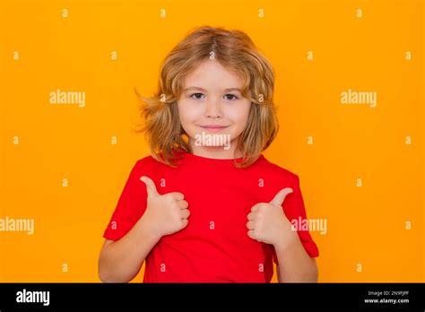 Child showing thumbs up on studio isolated background. Portrait of kid ...