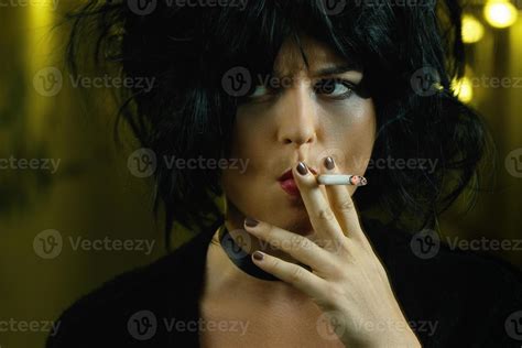 Freaky woman with black hair smoking a cigarette 16250080 Stock Photo