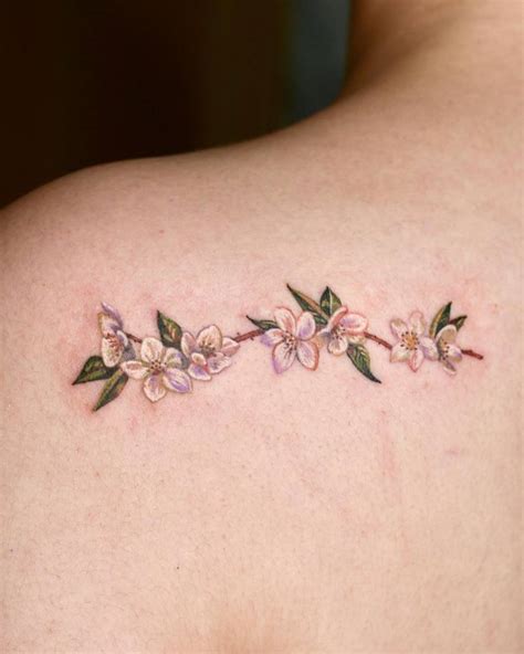 Pear blossom tattoo located on the shoulder blade,