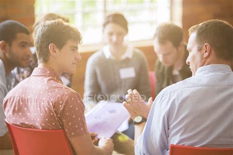 Men talking in group therapy session — meeting, explaining - Stock ...