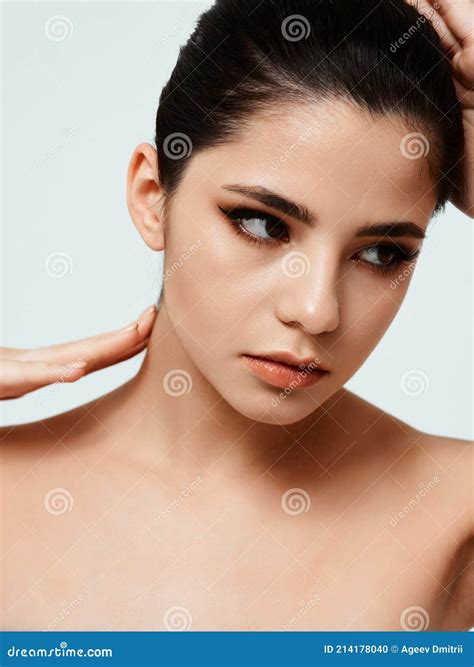Nude Brunette Touching Head with Hands Makeup on Face Model Stock Photo