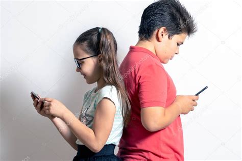 una nina   nino mirando telefonos inteligentes los ninos son pas