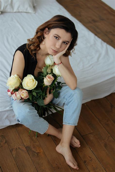 Woman Sitting and Holding Roses · Free Stock Photo