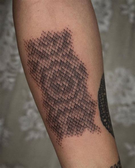 Snake scale tattoo located on the inner forearm.