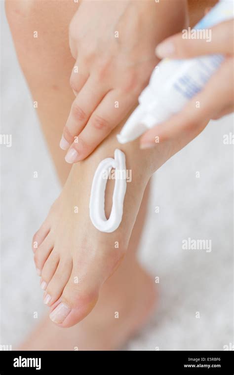 Woman applying moisturizing cream on her feet Stock Photo - Alamy