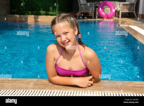 Smiling girl relaxing in swimming pool with turquoise water. Traveling and vacation concept ...