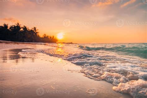 Beautiful blurred sunset over tropical paradise beach, waves splash ...