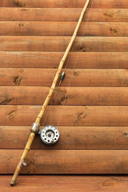 premium photo  fishing rod  wooden background