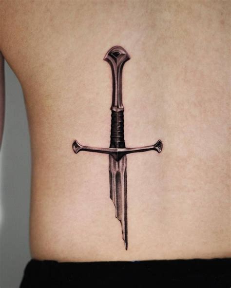 Black and grey style broken sword tattoo located on the