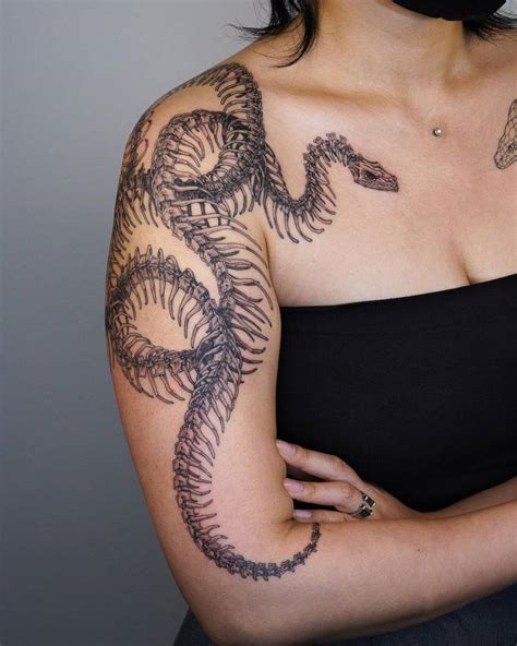 Large snake skeleton tattoo located on the upper arm