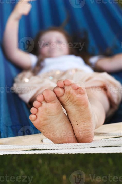 closeup of little girl's feet relaxing in the blue hammock during her ...