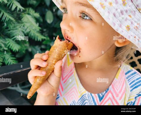 girl biting  popsicle   waffle cone stock photo alamy