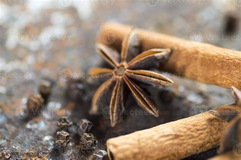 Cinnamon sticks, anise stars and black peppercorns on textured
