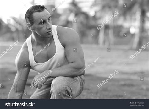 Muscular Man Squatting In A Park Setting Stock Photo 69026569 : Shutterstock