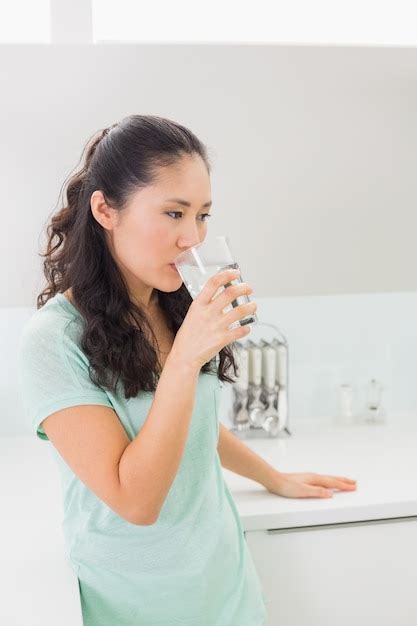premium photo young woman drinking water  kitchen
