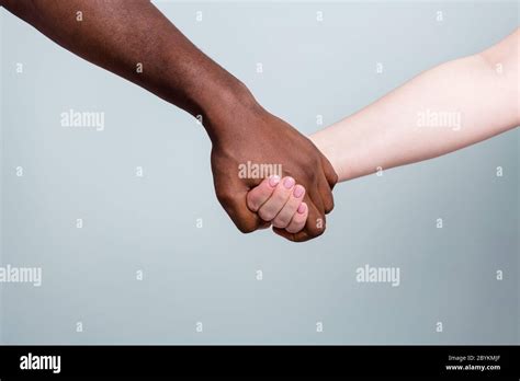 Closeup photo of two hands arms different race multinational couple ...