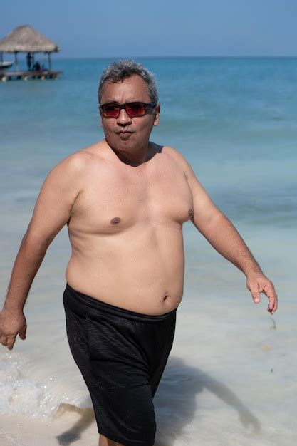 Premium Photo | Fat man with big stomach walking on the beach