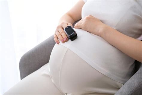 Premium Photo | A pregnant woman measures the pulse with a heart rate ...