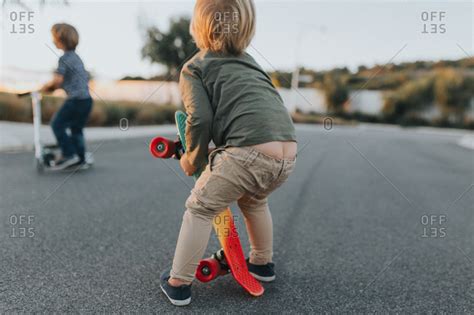 Toddler boy with pants falling down stock photo - OFFSET